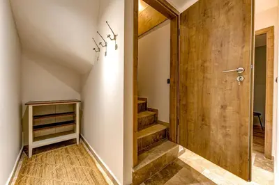 a hallway with a wooden door and stairs at Beautiful new flat by the forest in Chamonix-Mont-Blanc