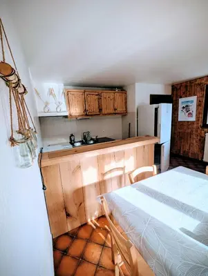 a kitchen with wooden cabinets and a bed in a room at Appartement 60m2 avec une vue exceptionnelle in Sallanches