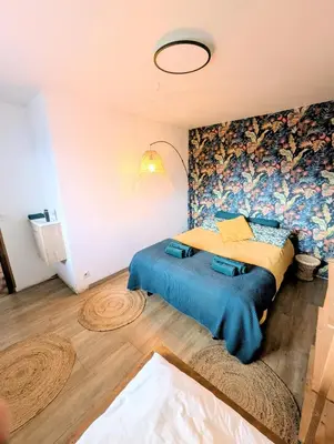 a bedroom with a large bed with a blue blanket at Appartement 60m2 avec une vue exceptionnelle in Sallanches
