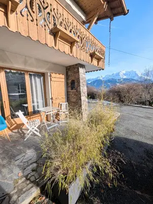 a house with a table and chairs on a patio at Appartement 60m2 avec une vue exceptionnelle in Sallanches