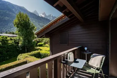 a balcony with a table and two chairs on it at Ancelles - Cocon 1CH Balcon Parking HomeCine CentrePraz in Chamonix-Mont-Blanc
