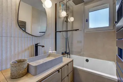 a bathroom with a sink and a mirror and a tub at Ancelles - Cocon 1CH Balcon Parking HomeCine CentrePraz in Chamonix-Mont-Blanc