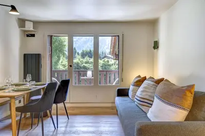 a living room with a couch and a table at Ancelles - Cocon 1CH Balcon Parking HomeCine CentrePraz in Chamonix-Mont-Blanc