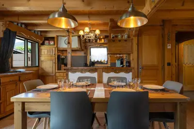 a dining room with a wooden table and chairs at Tete aux Vents - Chalet Familial Centre Vue Randos Parking in Chamonix-Mont-Blanc