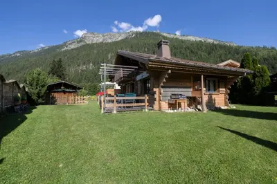 a log cabin with a mountain in the background at Tete aux Vents - Chalet Familial Centre Vue Randos Parking in Chamonix-Mont-Blanc