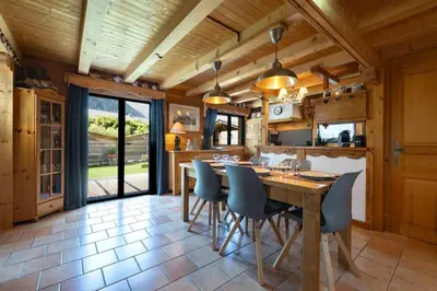 a kitchen with a wooden table and chairs at Tete aux Vents - Chalet Familial Centre Vue Randos Parking in Chamonix-Mont-Blanc