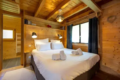 a bedroom with a bed in a log cabin at Tete aux Vents - Chalet Familial Centre Vue Randos Parking in Chamonix-Mont-Blanc