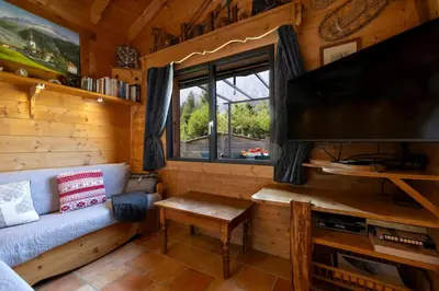 a living room with a couch and a flat screen tv at Tete aux Vents - Chalet Familial Centre Vue Randos Parking in Chamonix-Mont-Blanc