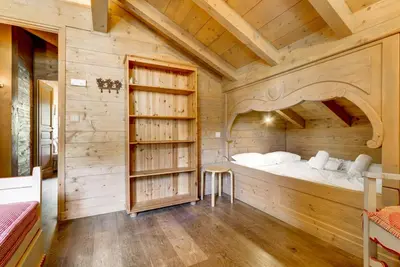 a bedroom with a bed in a wooden room at Michka - Chalet 500m Flegere Cheminee Jardin Vue 180 in Chamonix-Mont-Blanc