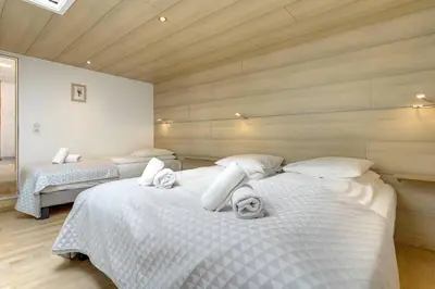 a bedroom with two beds with white sheets at Michka - Chalet 500m Flegere Cheminee Jardin Vue 180 in Chamonix-Mont-Blanc