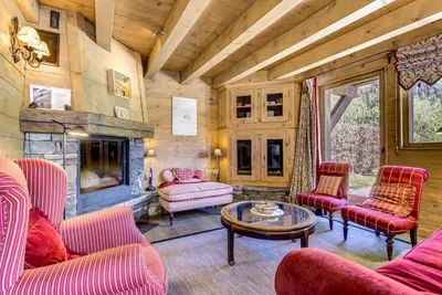 a living room with red furniture and a stone fireplace at Michka - Chalet 500m Flegere Cheminee Jardin Vue 180 in Chamonix-Mont-Blanc
