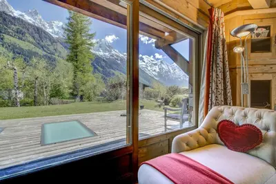 a bedroom with a window with a view of the mountains at Michka - Chalet 500m Flegere Cheminee Jardin Vue 180 in Chamonix-Mont-Blanc