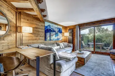 a living room with a couch and a table at Aurore - Cosy 74m2 Vue Jardin Remontee 250m Parking Bus in Chamonix-Mont-Blanc