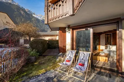 two chairs sitting on the porch of a house at Aurore - Cosy 74m2 Vue Jardin Remontee 250m Parking Bus in Chamonix-Mont-Blanc