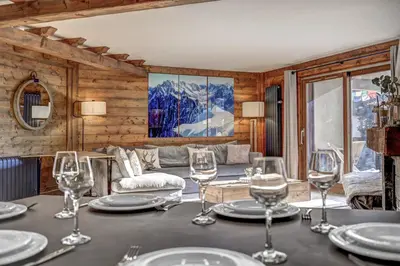 a dining room with a table with wine glasses at Aurore - Cosy 74m2 Vue Jardin Remontee 250m Parking Bus in Chamonix-Mont-Blanc