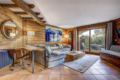 a living room with a couch and a table at Aurore - Cosy 74m2 Vue Jardin Remontee 250m Parking Bus in Chamonix-Mont-Blanc