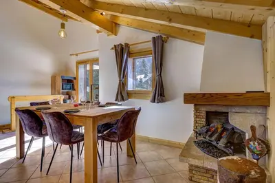 a dining room with a table and a fireplace at Passon - Appart 2CH 93m2 Sauna 300m Grand Montets Vue in Chamonix-Mont-Blanc