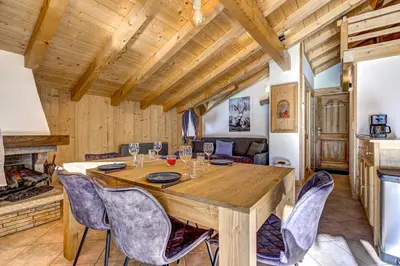 a dining room with a large wooden table and chairs at Passon - Appart 2CH 93m2 Sauna 300m Grand Montets Vue in Chamonix-Mont-Blanc