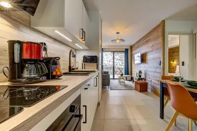 a living room with a couch and a tv on a wall at Kayla - Cosy 4pax Remontees 5mn Vue SPA Garage in Les Houches