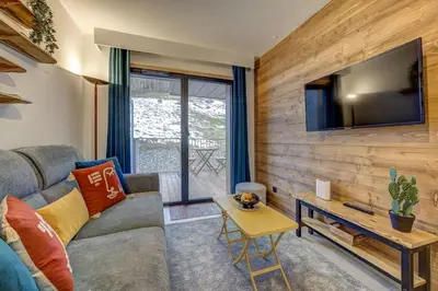 an apartment building with snow covered mountains in the background at Kayla - Cosy 4pax Remontees 5mn Vue SPA Garage in Les Houches