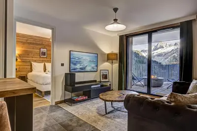 a living room with a bed and a view of a mountain at Brume - 2CH 2SDB Vues Remontees 400m Garage SPA in Les Houches