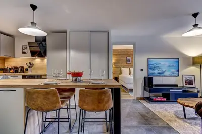 a kitchen and living room with a table and chairs at Brume - 2CH 2SDB Vues Remontees 400m Garage SPA in Les Houches