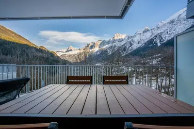 a deck with two benches and a view of mountains at Brume - 2CH 2SDB Vues Remontees 400m Garage SPA in Les Houches