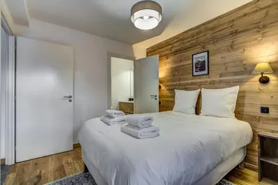 a bedroom with a white bed with towels on it at Brume - 2CH 2SDB Vues Remontees 400m Garage SPA in Les Houches