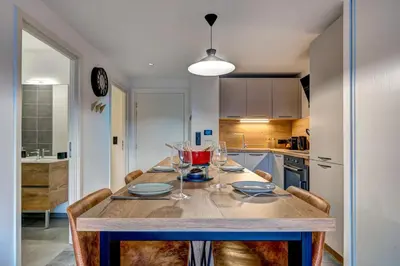 a kitchen with a table with wine glasses on it at Brume - 2CH 2SDB Vues Remontees 400m Garage SPA in Les Houches