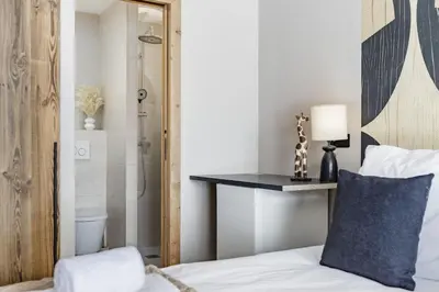 a bedroom with a bed with a blue pillow and a shower at 7 Summits - Chalet 230m2 Salon Cathedrale Vues Cheminee in Les Houches
