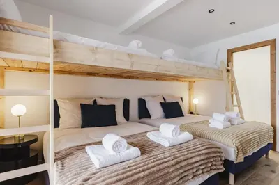 two beds in a room with two bunk beds at 7 Summits - Chalet 230m2 Salon Cathedrale Vues Cheminee in Les Houches