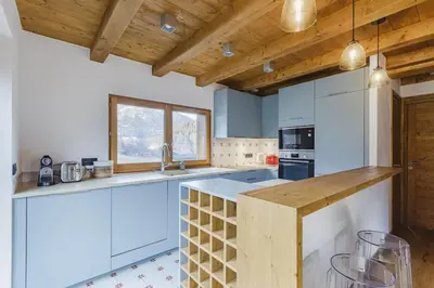 a kitchen with blue cabinets and a wooden ceiling at Marmottes - Chalet 7CH Familial 200m2 Cheminee Calme Vue in Les Houches