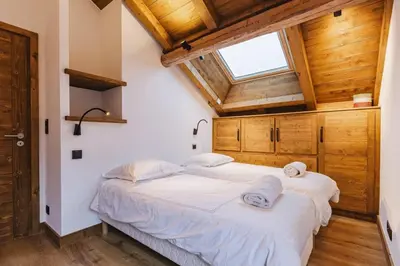 two beds in a room with wooden ceilings at Marmottes - Chalet 7CH Familial 200m2 Cheminee Calme Vue in Les Houches