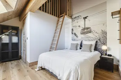 a bedroom with a bed and a wall with a ladder at Ciel - Duplex 100m2 Centre Vues Parking 3CH 3SDB in Chamonix-Mont-Blanc