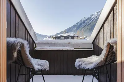 two chairs on a balcony with snow on them at Ciel - Duplex 100m2 Centre Vues Parking 3CH 3SDB in Chamonix-Mont-Blanc