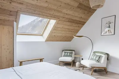 a bedroom with a bed and two chairs at Ciel - Duplex 100m2 Centre Vues Parking 3CH 3SDB in Chamonix-Mont-Blanc