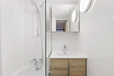 a bathroom with a sink and a shower and a mirror at Grand Roc - Cosy Duplex Grands Montets Balcon Vue Parking in Chamonix-Mont-Blanc