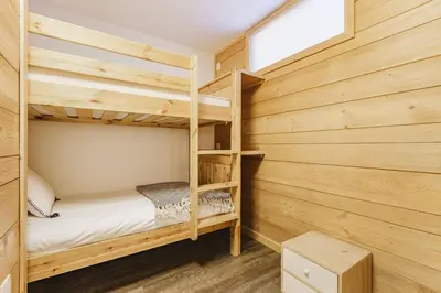 a bedroom with two bunk beds in a log cabin at Grand Roc - Cosy Duplex Grands Montets Balcon Vue Parking in Chamonix-Mont-Blanc
