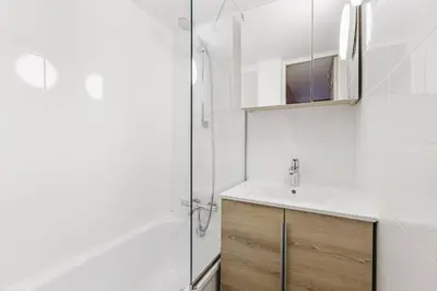 a white bathroom with a sink and a shower at Grand Roc - Cosy Duplex Grands Montets Balcon Vue Parking in Chamonix-Mont-Blanc