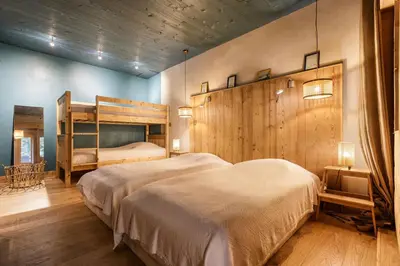 a bedroom with two beds and a wooden wall at Loft Bellevue Remonte Centre Piscine Parking in Les Houches