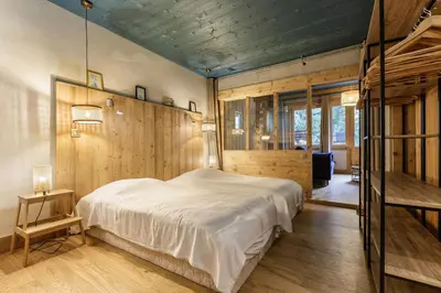 a bedroom with a large white bed and wooden walls at Loft Bellevue Remonte Centre Piscine Parking in Les Houches