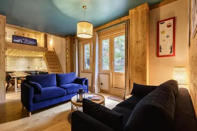 a living room with blue couches and a table at Loft Bellevue Remonte Centre Piscine Parking in Les Houches