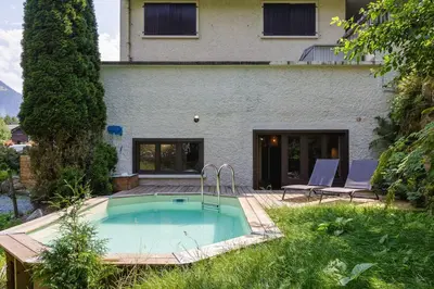 a swimming pool in front of a house at Loft Bellevue Remonte Centre Piscine Parking in Les Houches