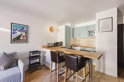 a kitchen with a table and chairs in a room at Beckett - Cocon familial Central Balcon Vue 200m Gare in Chamonix-Mont-Blanc