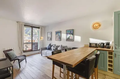 a living room with a table and a couch at Beckett - Cocon familial Central Balcon Vue 200m Gare in Chamonix-Mont-Blanc