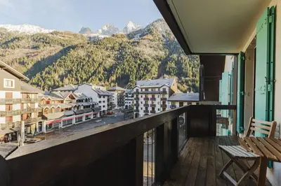 a balcony with a view of a town and mountains at Beckett - Cocon familial Central Balcon Vue 200m Gare in Chamonix-Mont-Blanc