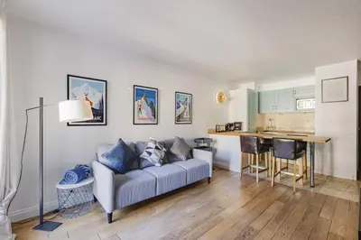 a living room with a couch and a kitchen at Beckett - Cocon familial Central Balcon Vue 200m Gare in Chamonix-Mont-Blanc