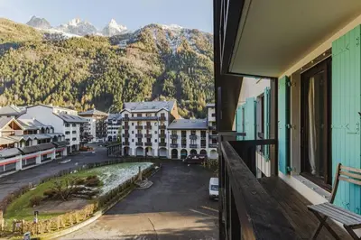 a balcony with a view of a street and mountains at Beckett - Cocon familial Central Balcon Vue 200m Gare in Chamonix-Mont-Blanc