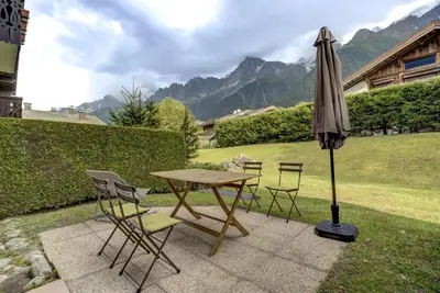 a table and chairs and an umbrella on a patio at Aiguilles Rouges - Apart 4pax Vues Terrasse Calme 50m Super U in Les Houches