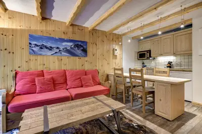 a living room with a red couch and a table at Aiguilles Rouges - Apart 4pax Vues Terrasse Calme 50m Super U in Les Houches